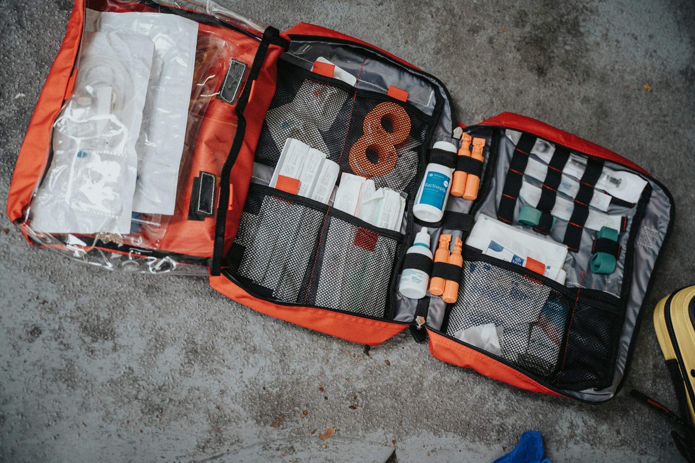 A compact and organized earthquake emergency kit with water, tools, medical supplies, and documents.